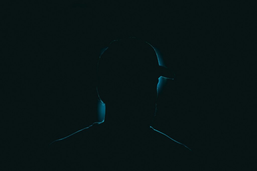 Silhouette einer Person steht im Dunkeln vor unscharfem Hintergrund, passend zum Thema Digitalisierung