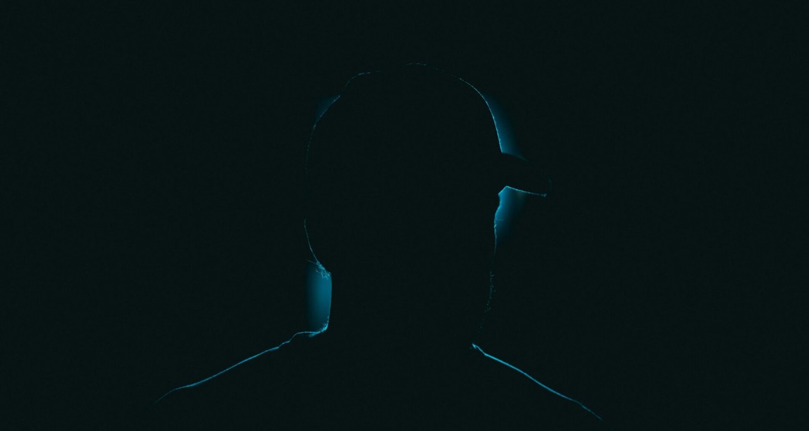 Silhouette einer Person steht im Dunkeln vor unscharfem Hintergrund, passend zum Thema Digitalisierung