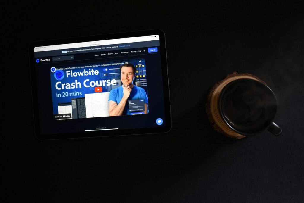 Ein Tablet liegt auf einer Oberfläche, daneben eine einzelne Münze, Symbol für Digitalisierung und Finanzen