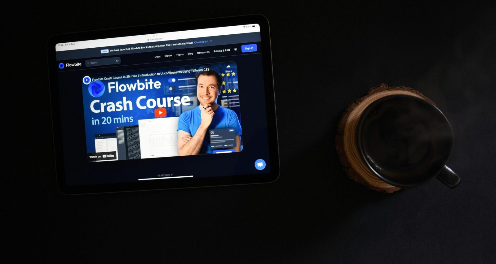 Ein Tablet liegt neben einer einzelnen Münze auf einem hellen Untergrund, Fokus auf Technik und digitale Zahlungsmittel.