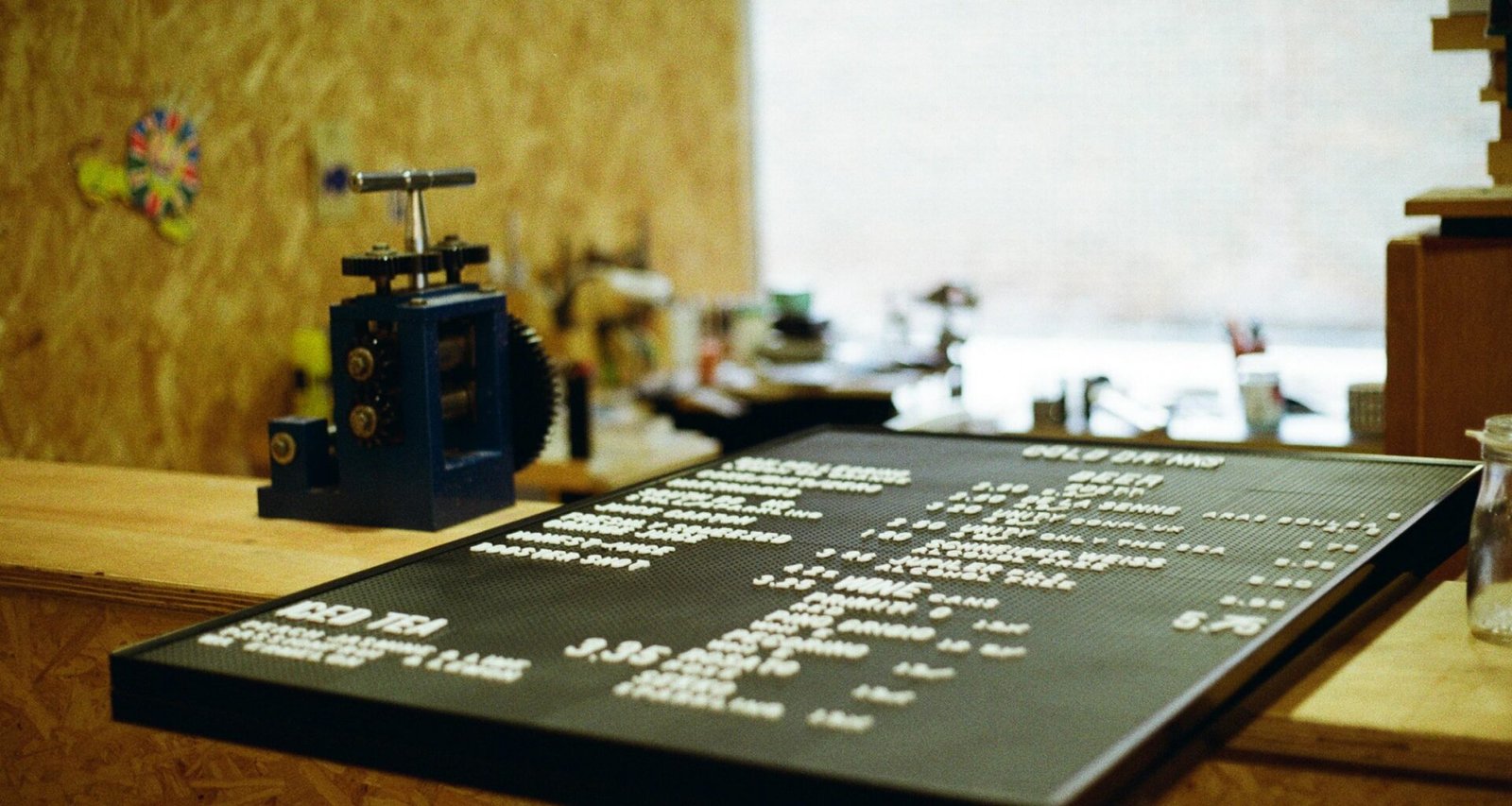 Eine Kreidetafel mit Menübeschriftung steht auf einer Theke und präsentiert Speisen und Getränke im Café.