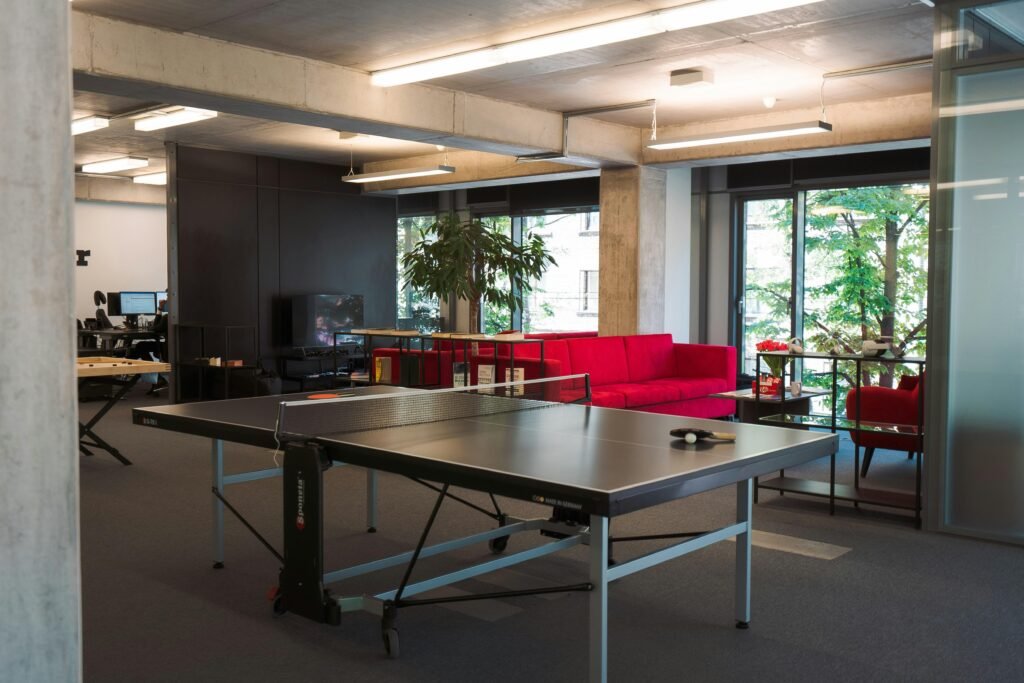 Ping Pong Tisch in einem hellen, modernen Büro, integriert als Teil der Büroausstattung und Freizeitgestaltung.