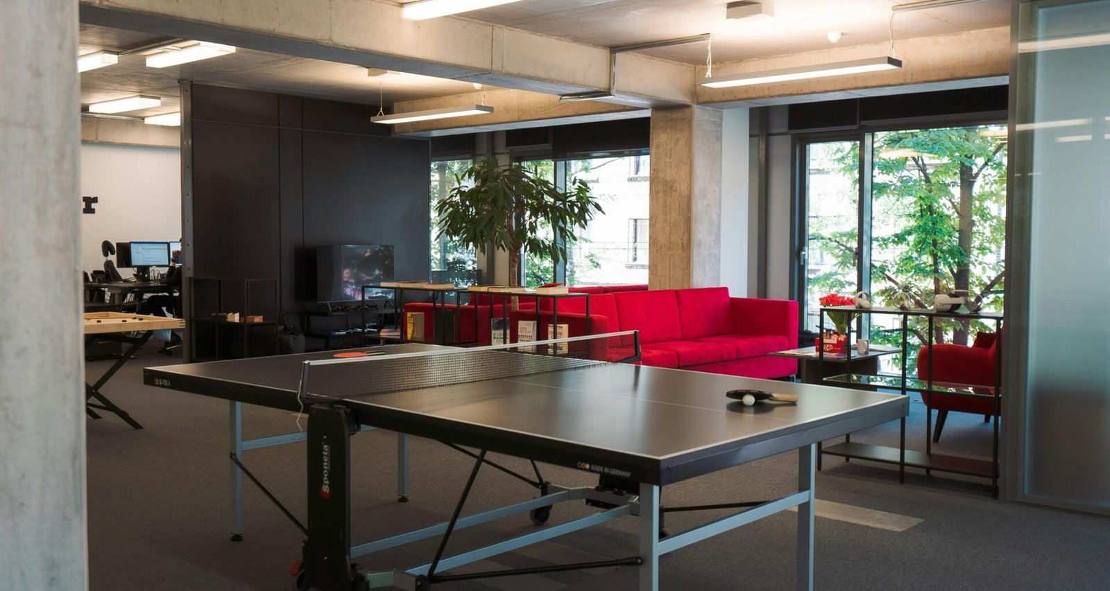 Ping Pong Tisch in einem hellen, modernen Büro, integriert als Teil der Büroausstattung und Freizeitgestaltung.