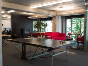 Ping Pong Tisch in einem hellen, modernen Büro, integriert als Teil der Büroausstattung und Freizeitgestaltung.