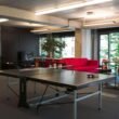 Ping Pong Tisch in einem modernen Büro mit heller Einrichtung und Arbeitsplätzen im Hintergrund