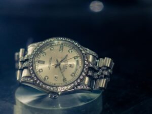 Moderne Armbanduhr liegt auf einem Glas­-Tisch und spiegelt Details von Zeit und Design wider.