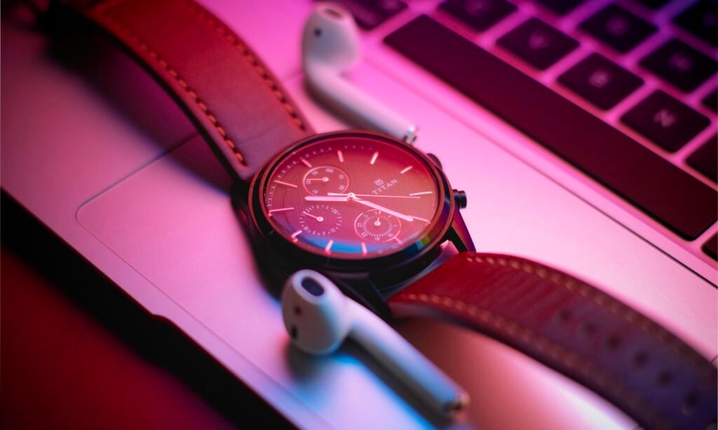 Nahaufnahme einer klassischen Armbanduhr, die auf einem modernen Laptop liegt – Fokus auf Zeitmanagement am Arbeitsplatz.