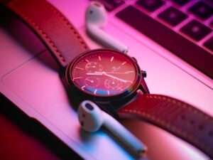 Nahaufnahme einer klassischen Armbanduhr, die auf einem modernen Laptop liegt – Fokus auf Zeitmanagement am Arbeitsplatz.