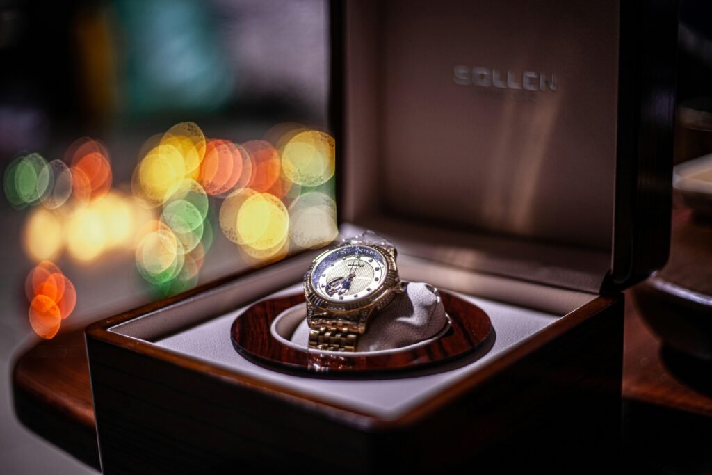 Armbanduhr in einer offenen Box auf einem Holztisch, passend für Beiträge über Technik oder Zeitmanagement