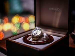 Armbanduhr in einer offenen Box auf einem Holztisch, passend für Beiträge über Technik oder Zeitmanagement