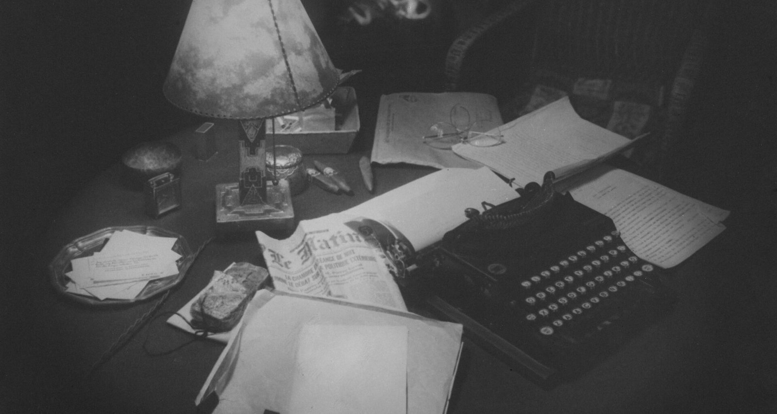 Eine alte Schreibmaschine zusammen mit Blättern Papier auf einem Holztisch, perfektes Motiv für Themen zu Schreiben und Kreativität.