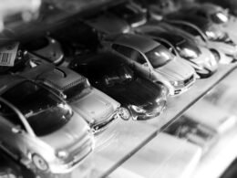 Eine Vitrine voller verschiedener Spielzeugautos, ordentlich aufgereiht und von vorne fotografiert.