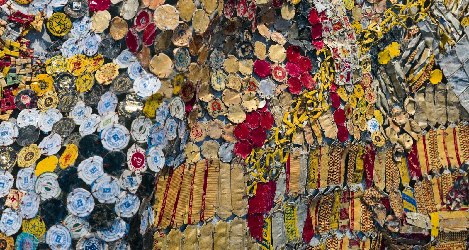 Verschiedene Arten von Buttons bedecken dicht an dicht eine große Wand, fotografiert von Eric Prouzet.