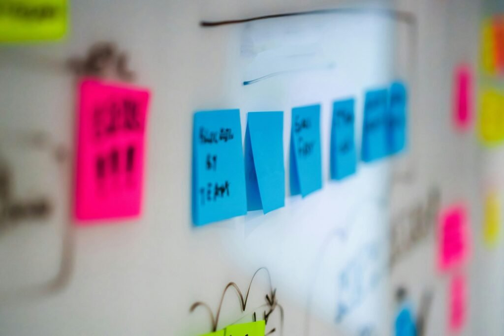 Wand mit verschiedenen farbigen Klebezetteln, die für eine Projektplanung oder ein Brainstorming genutzt werden