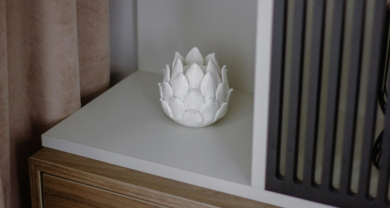 Weiße Vase auf hölzerner Kommode im modernen Einrichtungsstil, Objekt zentral platziert und schlicht inszeniert