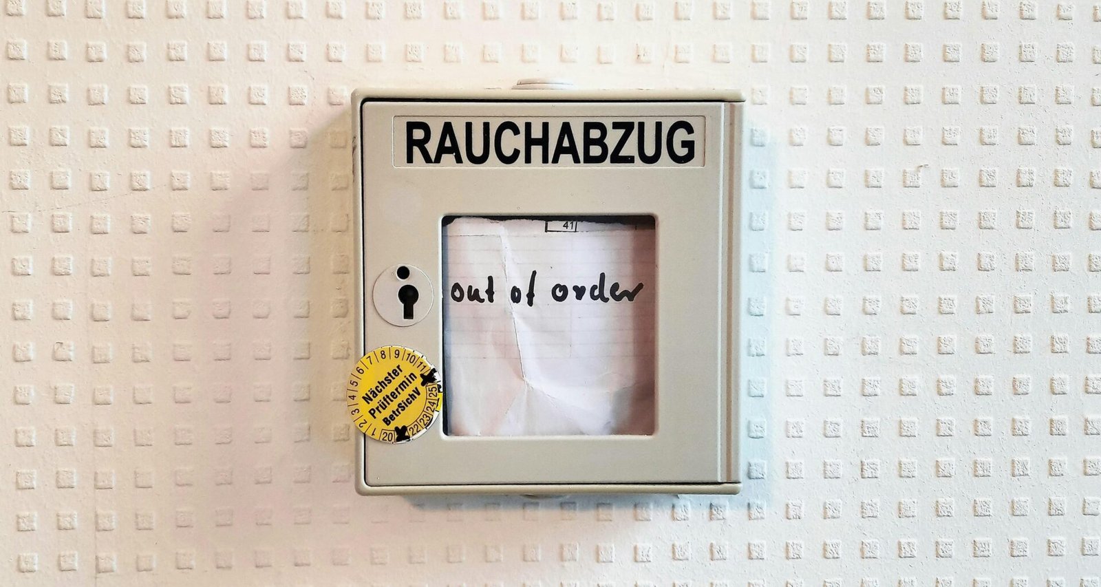 Ein Bilderrahmen mit dem Foto einer Person steht auf einer ebenen Oberfläche, Fokus auf Rahmen und Fotografie.