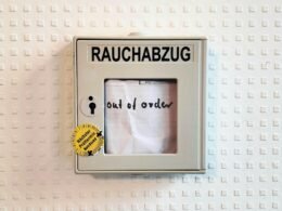 Ein Bilderrahmen mit dem Foto einer Person steht auf einer ebenen Oberfläche, Fokus auf Rahmen und Fotografie.