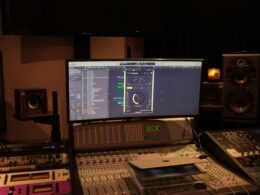 Computer mit Lautsprechern und Tastatur auf einem Schreibtisch, moderner Arbeitsplatz mit technischer Ausstattung