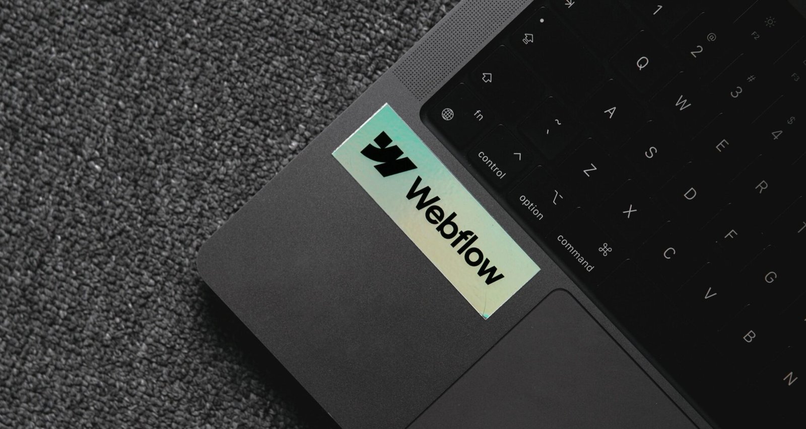 Laptop mit Fenster-Aufkleber auf der Tastatur, zeigt einen modernen Arbeitsplatz für digitale Projekte