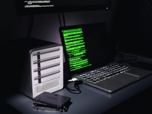 Laptop und Desktop-Computer nebeneinander auf einem Schreibtisch, moderner Arbeitsplatz mit technischen Geräten