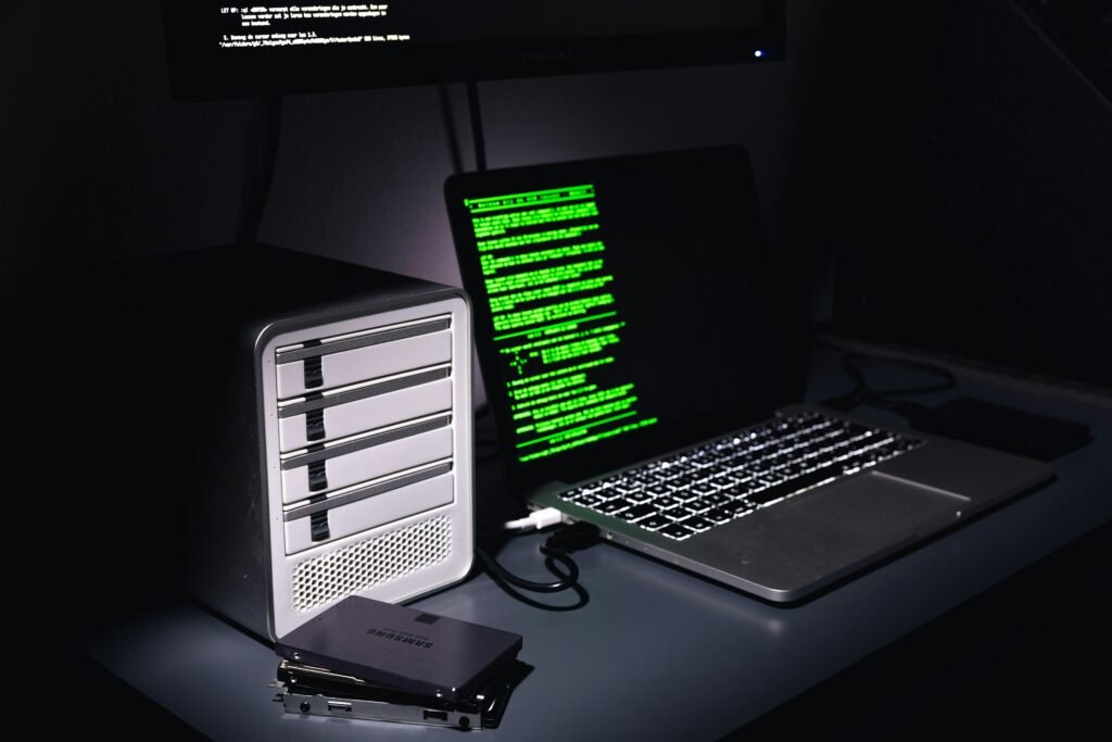 Ein Laptop und ein Desktop-Computer stehen nebeneinander auf einem Schreibtisch in einem modernen Arbeitsumfeld.