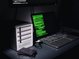 Ein Laptop und ein Desktop-Computer stehen nebeneinander auf einem Schreibtisch in einem modernen Arbeitsumfeld.