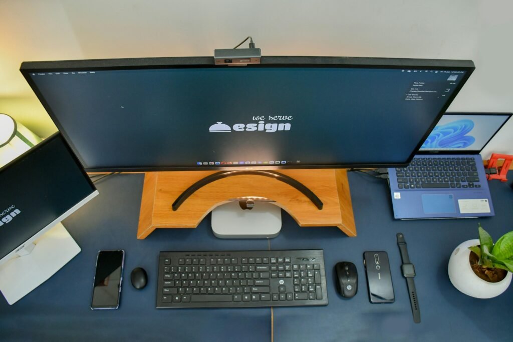 Ein heller Schreibtisch mit einem Computer und einem Smartphone, ideal für produktives Arbeiten im Büro oder Homeoffice.