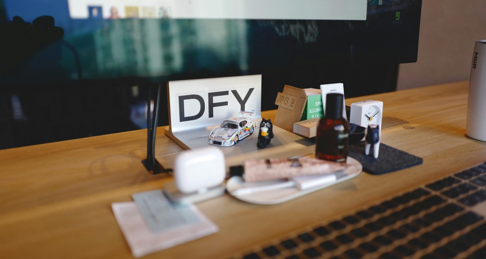 Schreibtisch mit einer weißen Tastatur, Maus und einem Bildschirm, perfekt für digitales Arbeiten im Büro eingerichtet.