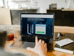 Angeschaltetes MacBook auf einem Schreibtisch, geöffnet und betriebsbereit, fotografiert in einer modernen Arbeitsumgebung