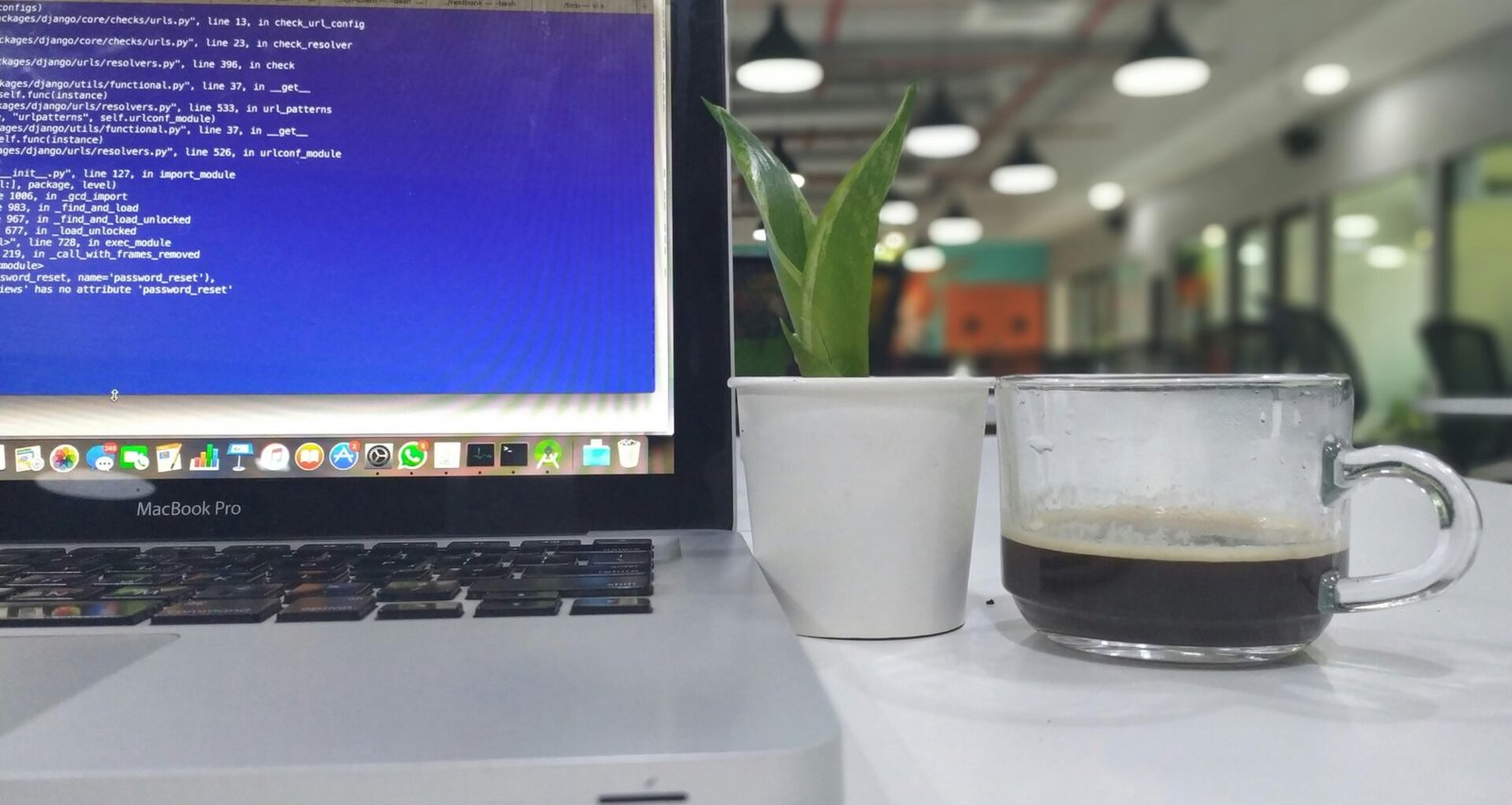 Eingeschaltetes MacBook Pro in Nahaufnahme auf einem Schreibtisch mit klar erkennbarer Tastatur und Display