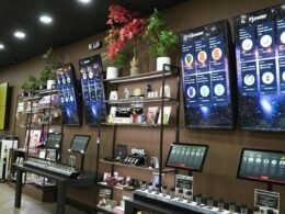 Einzelhandelsgeschäft mit Regalen, Produkten und Digitaldisplays zur Präsentation von Waren im Ladenbereich