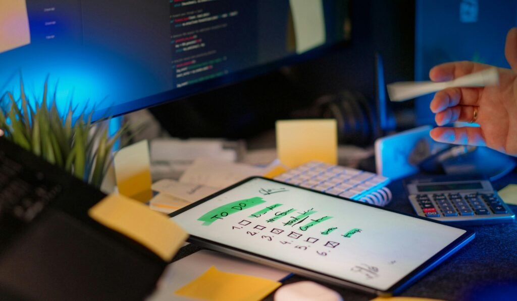 Entwickler programmiert an mehreren Monitoren in einem abgedunkelten Büro mit moderner Technik