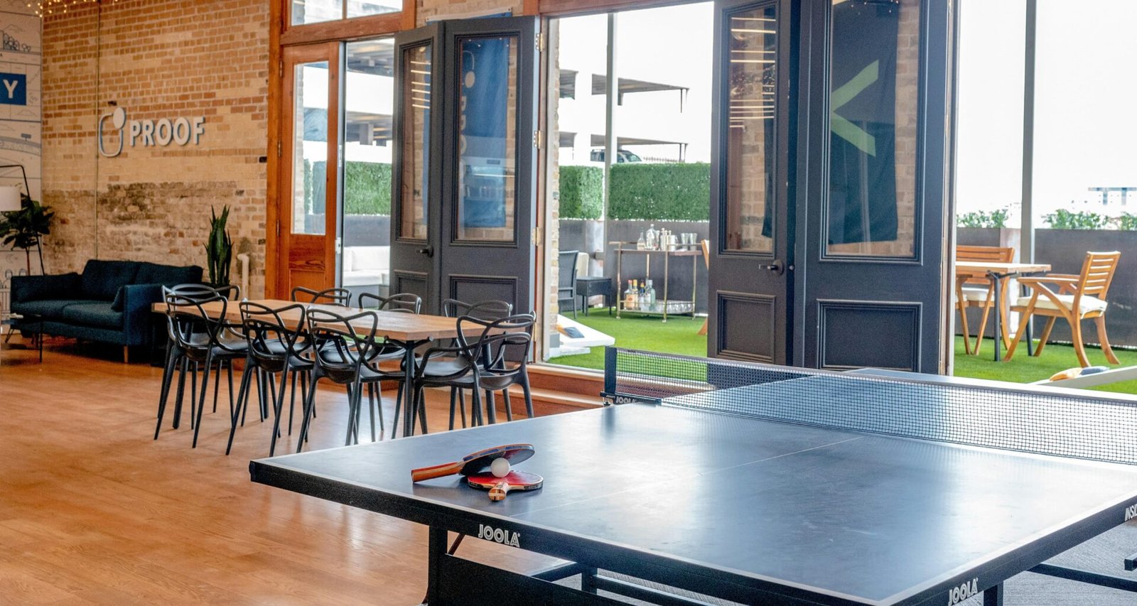 Eine zeitgemäße Essgruppe steht neben einer Tischtennisplatte in einem offen gestalteten Raum mit gemütlicher Atmosphäre.