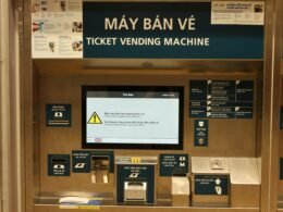 Ein Ticketautomat mit digitalem Bildschirm und Touchdisplay in einer öffentlichen Umgebung.