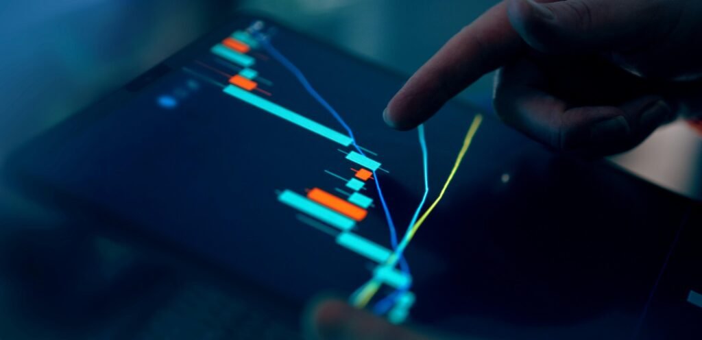 Hand tippt auf Tablet, das einen Börsengraphen anzeigt, Symbol für digitale Finanzanalyse und moderne Technologie