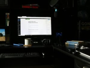 Flacher Computerbildschirm auf Schreibtisch, Monitor zeigt leeren Desktop, modernes Büroarbeitsumfeld