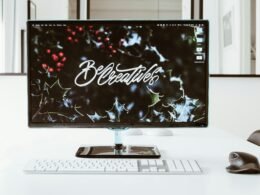 Flachbildschirm-Computer eingeschaltet auf Schreibtisch, moderner Arbeitsplatz, Fokus auf Technik und Digitalisierung