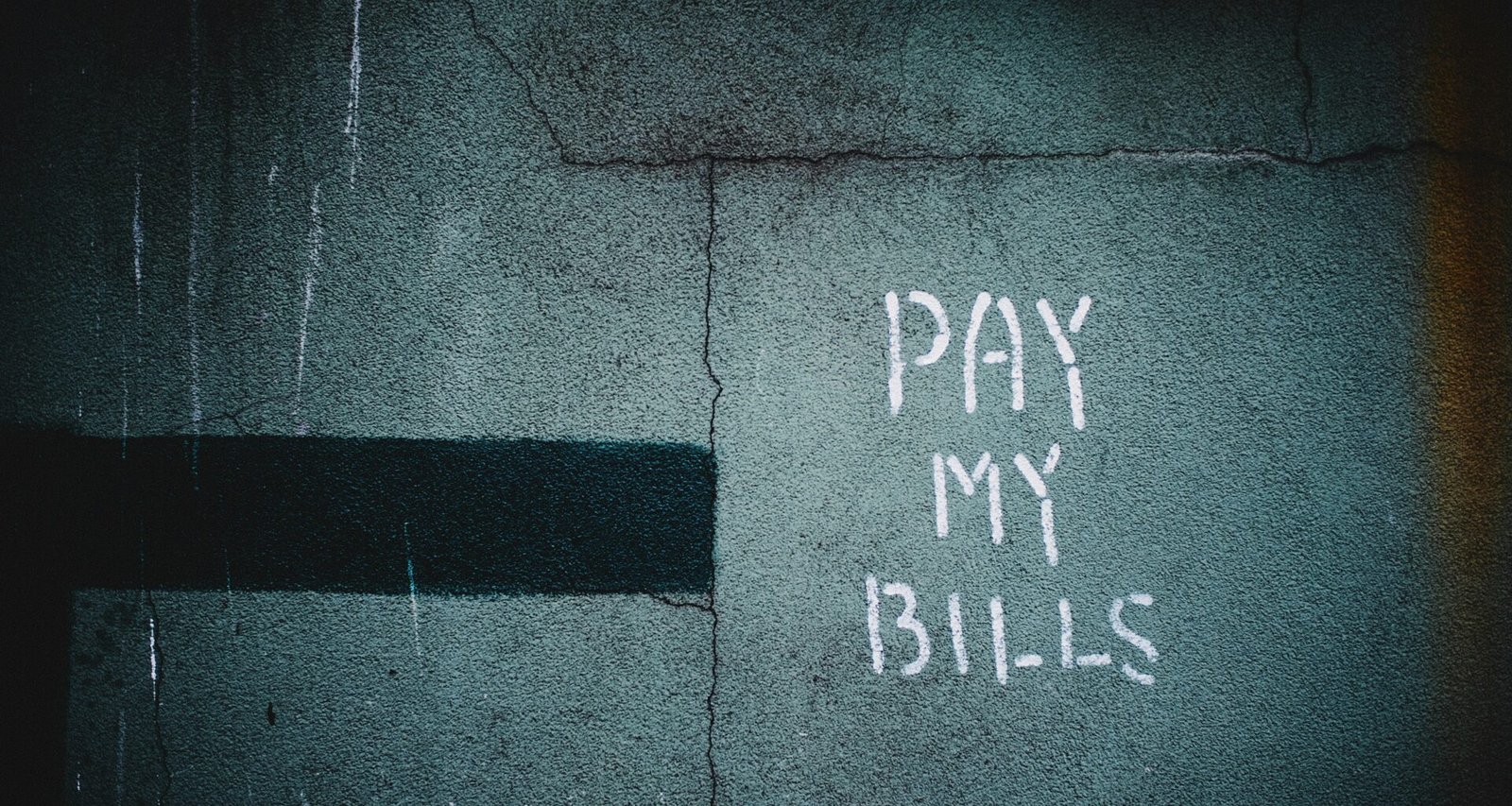 Schriftzug „Pay My Bills“ als Graffiti auf einer Wand, unscharf fotografiert und als Symbol urbaner Street-Art dargestellt