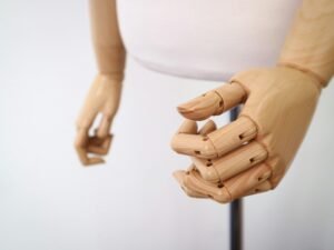 Nahaufnahme einer braunen Holzpuppe mit unscharfem Hintergrund, passend für kreative Themen und visuelle Inspiration.