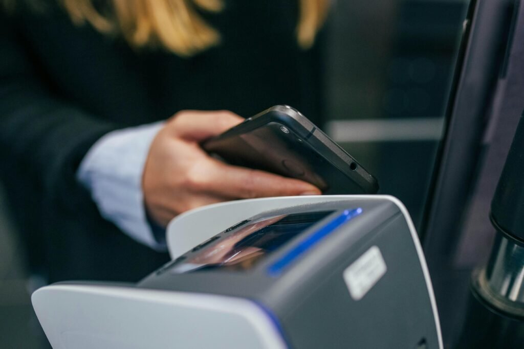 Eine Hand hält ein Smartphone, Aufnahme in geringer Schärfentiefe mit Fokus auf das Gerät