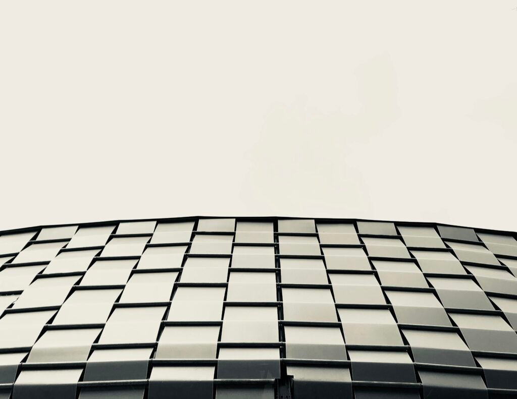 Niedrigwinkelaufnahme eines modernen grauen Gebäudes, das die klaren Linien und Strukturen der Architektur hervorhebt