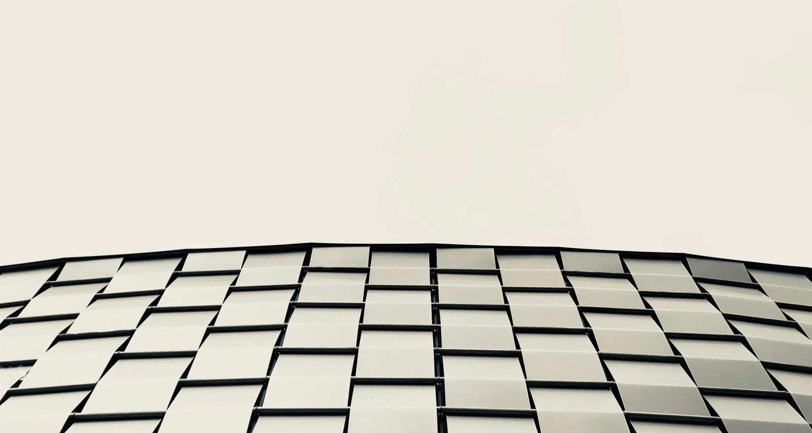 Niedrigwinkelaufnahme eines modernen grauen Gebäudes, das die klaren Linien und Strukturen der Architektur hervorhebt