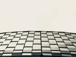 Niedrigwinkelaufnahme eines modernen grauen Gebäudes, das die klaren Linien und Strukturen der Architektur hervorhebt