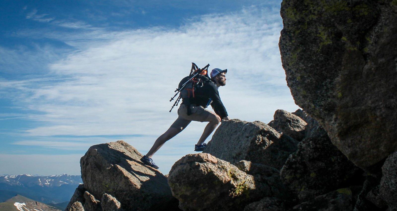 Ein Mann klettert einen felsigen Berg hinauf, Aufstieg bei Tageslicht, symbolisiert Herausforderungen im Digitalbereich