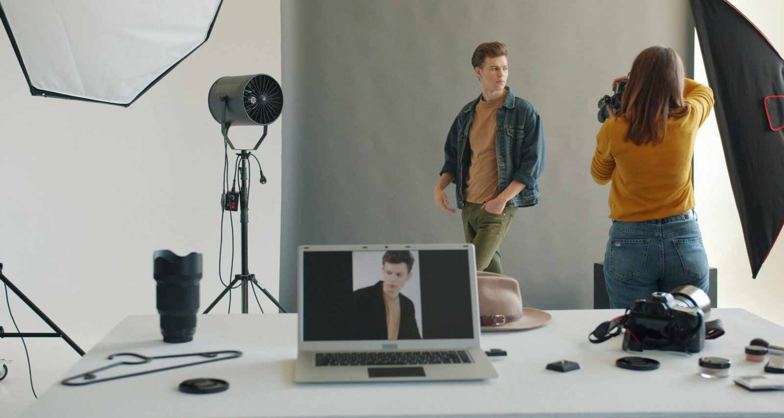 Fotograf nimmt in einem professionellen Studio gezielt eine männliche Schaufensterpuppe mit der Kamera auf