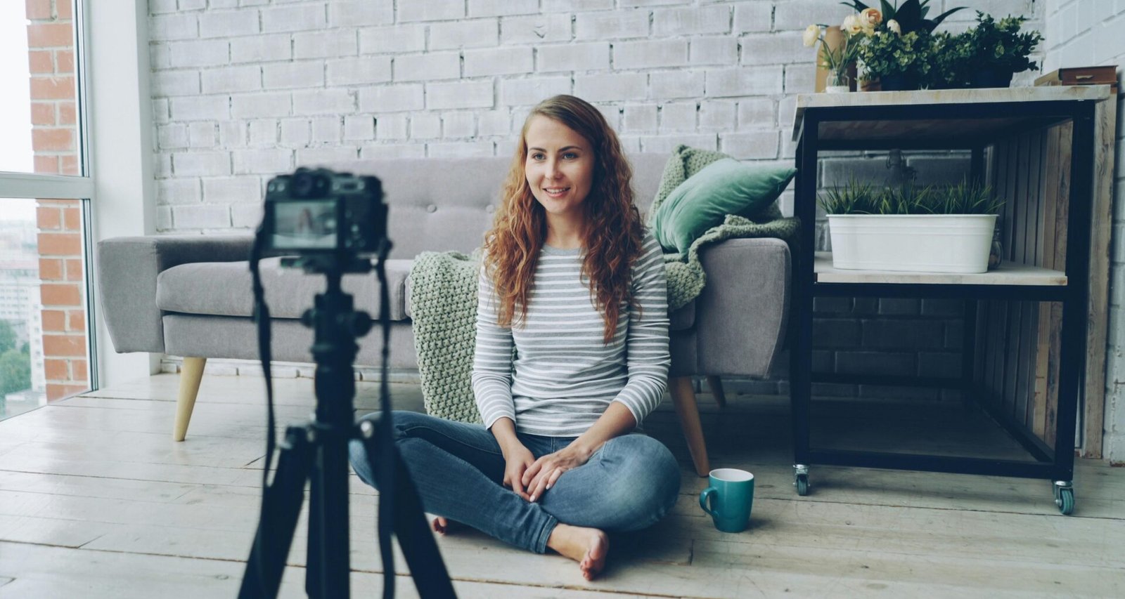 Frau filmt sich mit einer Kamera in einem gut beleuchteten Raum, ideal für Homeoffice- oder Vlogging-Artikel