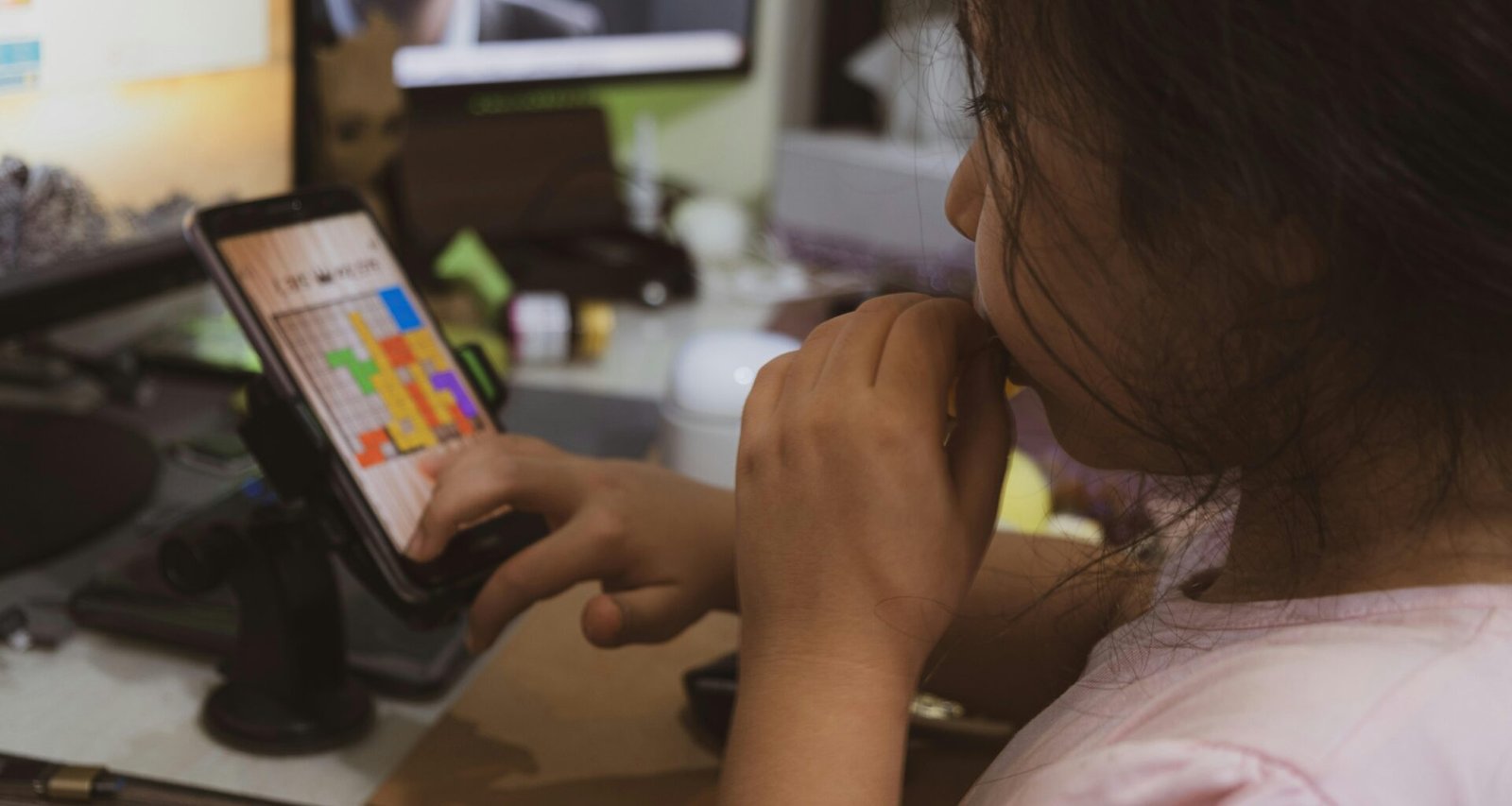 Frau im pinken Shirt hält ein Smartphone in der Hand und nutzt es, Fokus auf mobile Kommunikation im Alltag