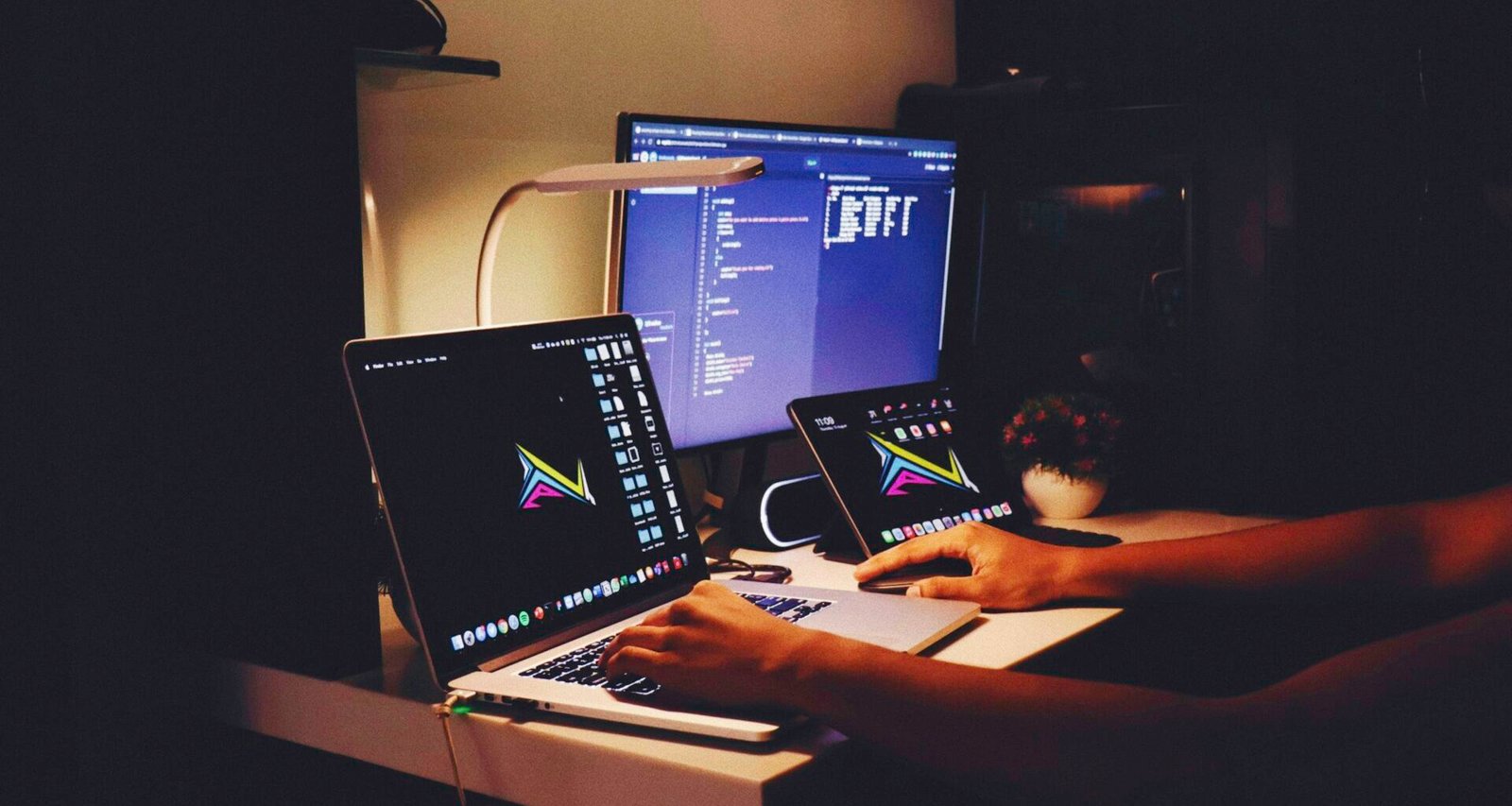 Frau in schwarzem Tanktop arbeitet an einem Computerbildschirm an einem modernen Schreibtisch