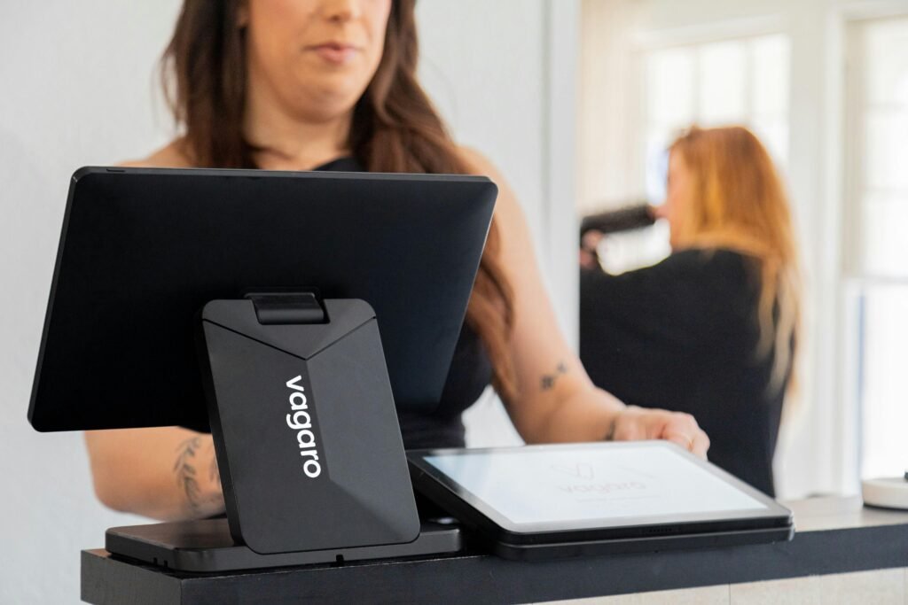 Frau arbeitet mit einem Tablet an einer Kasse in einem Geschäft, modernes Bezahlsystem im Einzelhandel sichtbar