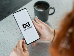 Frau zeigt Smartphone mit deutlich sichtbarem AI Workspace Logo in der Hand, Symbol für digitale Arbeitswelt